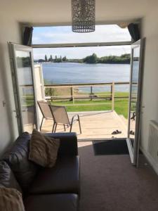 een woonkamer met een bank en uitzicht op het water bij Lake Lodges in Chichester