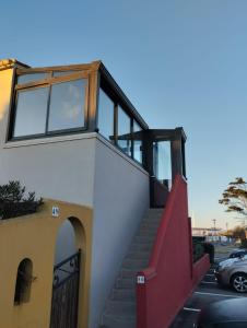ein Haus mit einer roten Treppe an der Seite in der Unterkunft Appartement 100 mètres plage avec parking privé in Le Barcarès