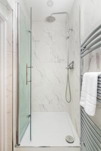 a shower with a glass door in a bathroom at Spacious apartment near Hammersmith staion in London