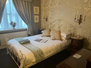 a bedroom with a white bed with a window at Angel at Bourne in Bourne