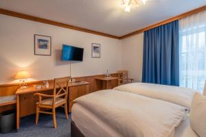 um quarto de hotel com uma cama e uma secretária e uma cama e uma secretária em AKZENT Hotel Frankenberg em Frankenberg