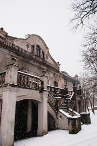 ein altes Gebäude mit Schnee auf dem Boden in der Unterkunft Linkuva Manor Apartment in Kaunas