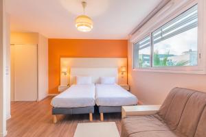 - une chambre avec un lit et un canapé dans l'établissement Appart’City Confort Montpellier Ovalie I, à Montpellier