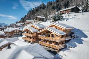 a large wooden house covered in snow at Chalet Floquet de Neu Les Gets- BY EMERALD STAY in Les Gets
