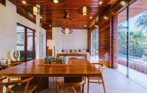 a dining room with a wooden table and chairs at EMHILL Estate Lombok in Selong Belanak
