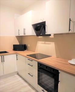 a kitchen with white cabinets and a stove top oven at Rynek 9 in Poznań