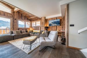 a living room with a couch and chairs and wood walls at Chalet Floquet de Neu Les Gets- BY EMERALD STAY in Les Gets