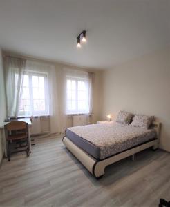 a bedroom with a bed and a desk and windows at Rynek 9 in Poznań