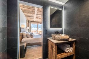 a bathroom with a sink and a bedroom at Chalet Floquet de Neu Les Gets- BY EMERALD STAY in Les Gets