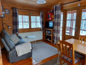 a living room with a couch and a table at Bakkakot 1 - Cozy Cabins in the Woods in Akureyri