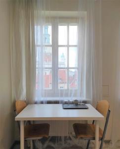uma mesa branca com cadeiras em frente a uma janela em Rynek 9 em Poznań