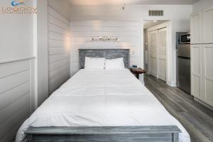 Cette chambre comprend un grand lit blanc et une cuisine. dans l'établissement PB A108-Executive Studio Condo at Great Rates!, à Fort Walton Beach