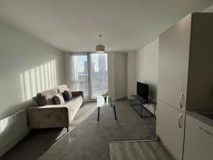 a living room with a couch and a tv at Modern 1 Bedroom Apartment Central Manchester in Manchester