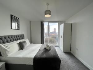 a bedroom with a large bed with a large window at Modern 1 Bedroom Apartment Central Manchester in Manchester