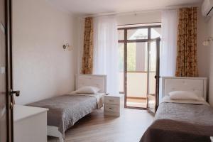 2 Betten in einem Zimmer mit Fenster in der Unterkunft Готель Хутір in Malyye Khutora