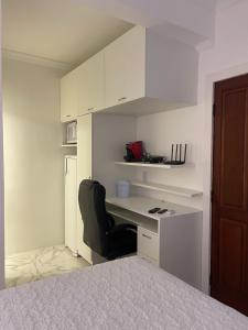 1 dormitorio con escritorio y silla junto a la cama en Suite privada, en Salvador