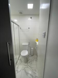 baño con aseo y puerta de ducha de cristal en Suite privada, en Salvador