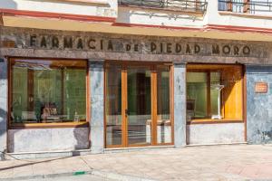 una tienda frente a una farmacia con ventanas de cristal en Apartamento turístico 'Botica Moro', en Boñar