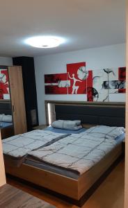 a large bed in a bedroom with posters on the wall at Appartement am Rondell in Hösbach