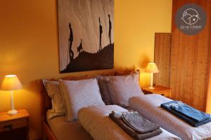 a bed in a room with two lamps and a couch at Chalet LES MARMOTTES, Ovronnaz in Ovronnaz