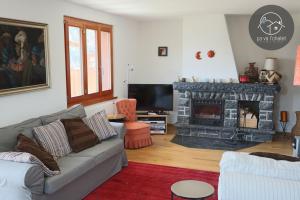 a living room with a couch and a fireplace at Chalet LES MARMOTTES, Ovronnaz in Ovronnaz