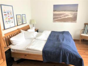 een slaapkamer met een bed met een blauwe deken erop bij Melissa in Westerland