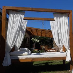 a canopy bed with white curtains in a yard at Ośrodek Wypoczynkowy Karolina in Stegna