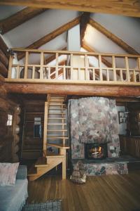 a living room with a staircase and a stone fireplace at Pilskalni in Sigulda