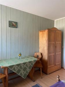 a dining room with a table and a wooden cabinet at Pod daglezją in Bronków