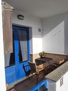 a patio with a table and chairs and a blue door at ISLOTE in Famara