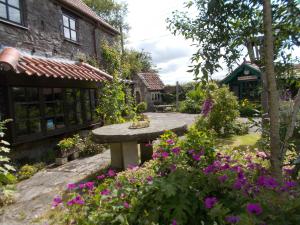 a garden with a stone bench and flowers at Spindle Cottage 