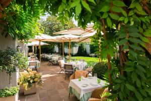 patio ze stołami i parasolami w ogrodzie w obiekcie Hotel Gasthof Brandstätter w mieście Salzburg
