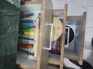 a wooden cabinet with a bunch of books in it at Homlee-Best Value flat with kitchen Near Metro in New Delhi