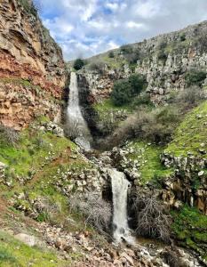 una cascada a un lado de una montaña rocosa en Luxury family caravan truck in the Golan Heights, en Bruchim Qela' Alon
