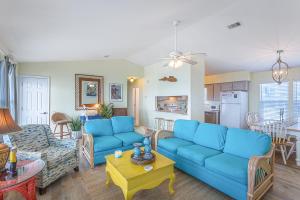 een woonkamer met blauwe banken en een keuken bij Driftwood in St. George Island