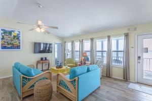 a living room with a blue couch and chairs at Driftwood in St. George Island