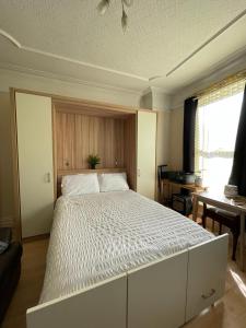 Room in family home near Penny Lane Liverpool في ليفربول: غرفة نوم مع سرير أبيض كبير في غرفة