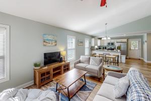a living room with a couch and a tv at Oak Island Oasis in Oak Island