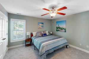 a bedroom with a bed and a ceiling fan at Oak Island Oasis in Oak Island