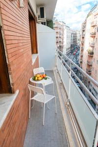 einen Balkon mit einem Tisch und Stühlen sowie einer Obstschale in der Unterkunft La Hara Apartments in Neapel