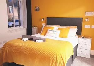 a bedroom with a large bed with a yellow blanket at Double Ensuite Bedroom near Edinburgh in Kirkcaldy