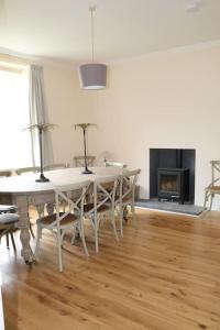 a dining room with a table and chairs and a fireplace at Oldwood. Fyvie. in Turriff