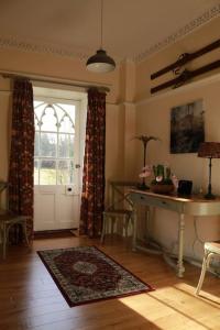 a living room with a door and a table and a window at Oldwood. Fyvie. in Turriff