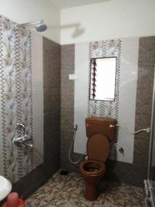 La salle de bains est pourvue d'une douche et de toilettes. dans l'établissement Acharekar's Home stay - Adorable AC and Non AC Rooms with free Wi-Fi, à Malvan