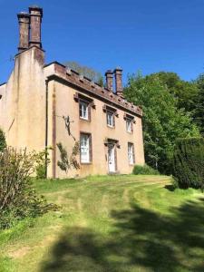 an old building with two chimneys on top of a field at Oldwood. Fyvie. in Turriff