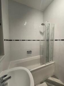 a bathroom with a tub and a toilet and a sink at A lovely 3 bedroom family house! in Seaham