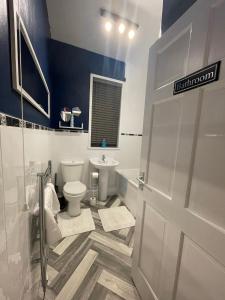 a bathroom with a toilet and a sink at A lovely 3 bedroom family house! in Seaham