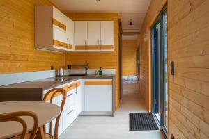 a small kitchen with white cabinets and a table at Arche Siedlisko Augustynka 39 in Augustynka