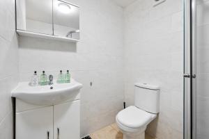 a white bathroom with a toilet and a sink at Apartment Nr City Centre & Park For up to 6 in Cardiff +16 photos