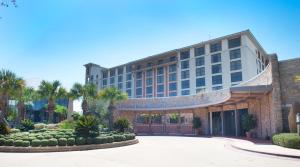 a hotel building with a courtyard and palm trees at Horseshoe Bay Resort in Horseshoe Bay